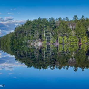 A beautiful calm, blue lake with the island and a fallen birch tree in the foreground. This landscape shot was taken as part of the filming of the 'Landscape Theatre - Lakefront' series by KiltRockMedia.com.